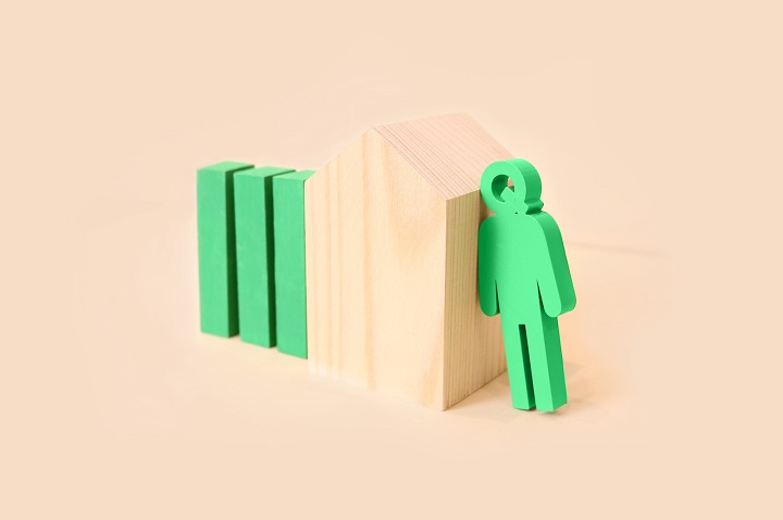 green queue man resting on beige wooden building block