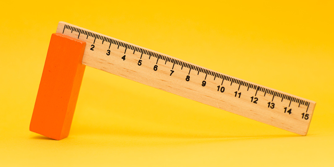 Wooden measuring ruler on yellow background